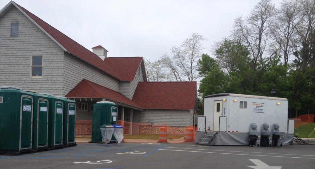 A restroom with a toilet and a trailer.